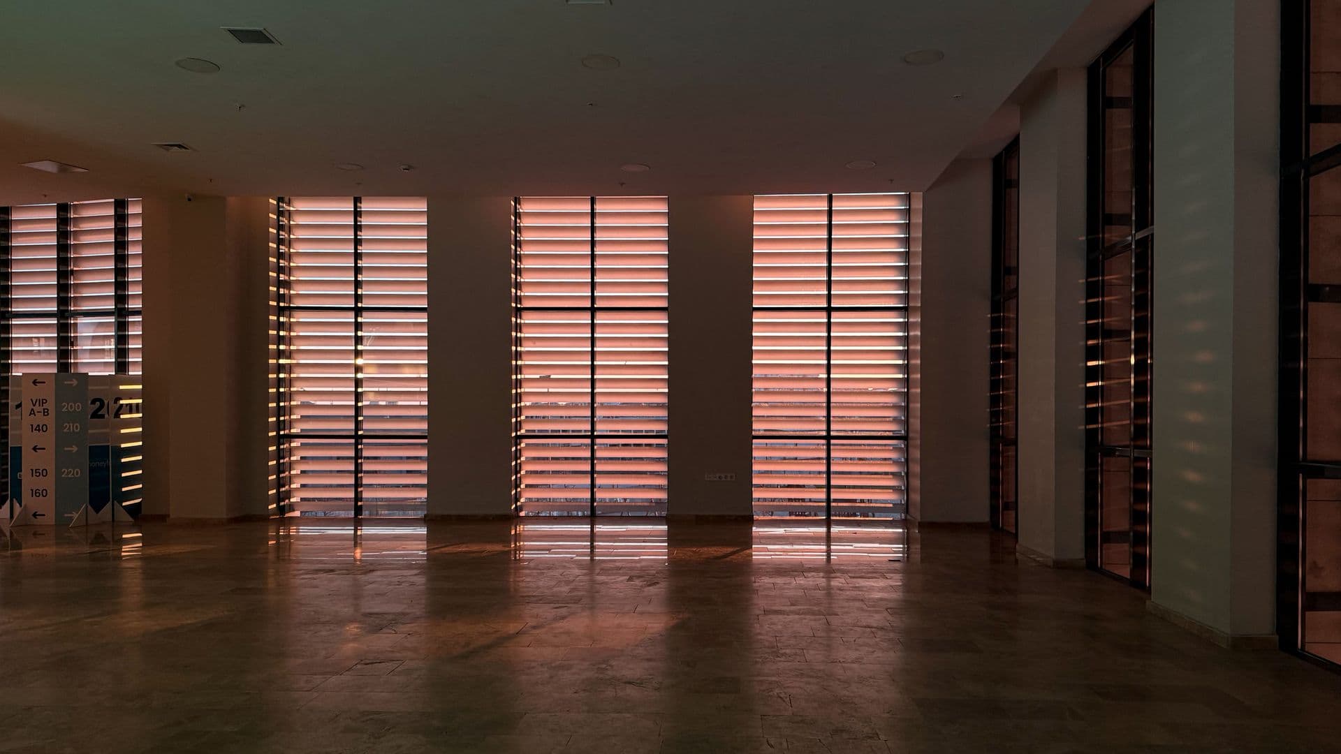 Sunlight filtering through automated louvered blinds in a modern London interior