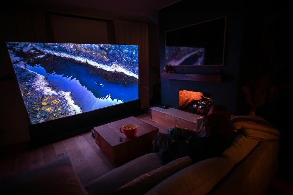 Family watching a film in their living room cinema with the lights dimmed